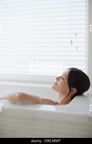 Donna relax nel bagno di bolle Foto Stock