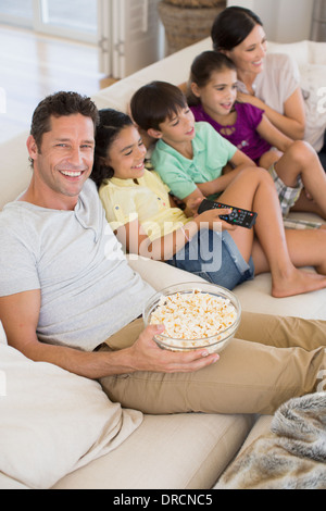 Famiglia di guardare la TV sul divano nel soggiorno Foto Stock