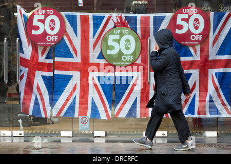 Una donna cammina oltre l'ex HMV store ora decorate con unione di bandiere e di prezzo off-segni, Coventry Street, Londra, Regno Unito Foto Stock