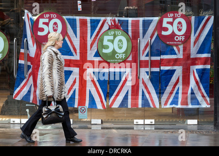 Una donna cammina oltre l'ex HMV store ora decorate con unione di bandiere e di prezzo off-segni, Coventry Street, Londra, Regno Unito Foto Stock