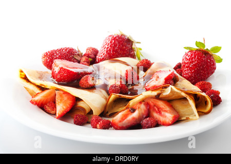 Frittelle con differenti le fragole con lo sciroppo di cioccolato su bianco Foto Stock