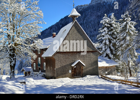 La neve che ricopre il legno antico Sant'Anna Cappella e il Berggasthaus in Rohrmoos Valley, vicino a Oberstdorf, Allgau, Baviera, Germania meridionale Foto Stock