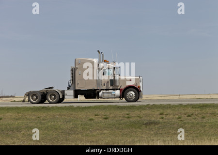 Semi camion sull'autostrada con sfocatura dello sfondo. Unico trattore voce da sinistra a destra senza rimorchio Foto Stock