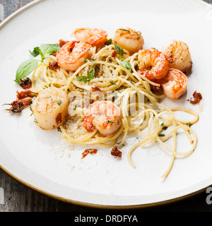 Spaghetti con gamberi e capesante di mare e scaglie di parmigiano Foto Stock