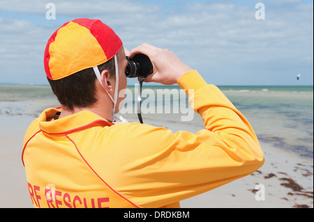 Giovane uomo life saver guardando la situazione sul mare Foto Stock