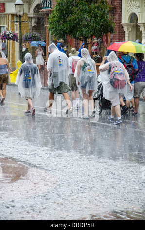 Famiglie indossano ponchos di scongiurare la pioggia a Magic Kingdom di Walt Disney World, a Orlando, Florida Foto Stock