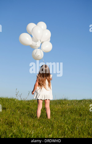 Ragazza con mazzo di palloncino in erba Foto Stock