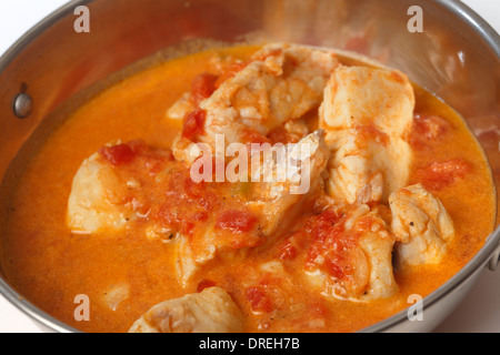 Base di pesce al curry, in una piccante di pomodoro e latte di cocco salsa kadai (karahi o un wok) ciotola, close-up Foto Stock