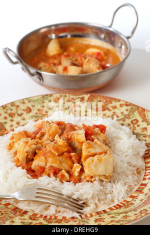 Base di pesce al curry, in una piccante di pomodoro e latte di cocco salsa, su un letto di riso basmati, con un kadai (karahi o un wok) ciotola Foto Stock