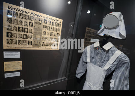 Hof, Germania. 24 gen 2014. Un poster raffigurante le foto dei bambini persi appeso accanto a un infermiere gli abiti nel reparto speciale 'i rifugiati e gli sfollati" nel museo Bayerisches Vogtland in Hof, Germania, 24 gennaio 2014. La città di Hof ha presentato i nuovi piani per il museo in occasione di una conferenza stampa. Foto: DAVID EBENER/dpa/Alamy Live News Foto Stock