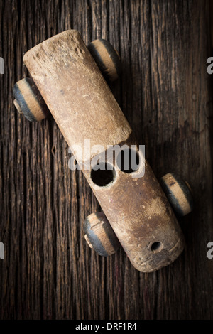 Un vecchio giocattolo di legno stagionato auto da anni di giocare su un vecchio rustico pavimento.