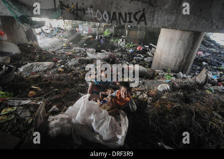 Paranaque, Filippine. 24 gen 2014. Bambini filippini giocare sotto un ponte affollato che utilizzano come un rifugio in Paranaque, suburbana Manila, Filippine, 24 gennaio 2014. Tra le acque al di sotto e il traffico che attraversa il sovraccarico, molte le famiglie filippine pilotato dalla povertà hanno istituito le residenze di fortuna sotto i ponti. Secondo le Nazioni Unite, un decimo di baraccati vivono in Metro Manila con 80.000 persone per chilometro quadrato in alcuni quartieri.Foto: Ezra Acayan/NurPhoto © Ezra Acayan/NurPhoto/ZUMAPRESS.com/Alamy Live News Foto Stock