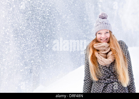 Donna bionda contro nevicata, ritratto, Spitzingsee, Baviera, Germania Foto Stock