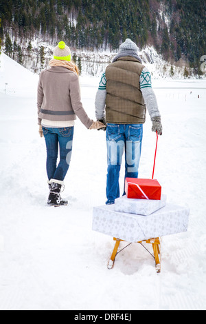 Giovane tirando i regali sulla slitta, Spitzingsee, Baviera, Germania Foto Stock
