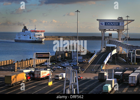 Un traghetto entra in porto in una giornata di sole come coda di camion per imbarcarsi in Eastern Docks Foto Stock