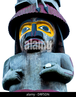 Una figura su un nativo del totem pole è intagliato a mano fuori del cedro rosso. Foto Stock