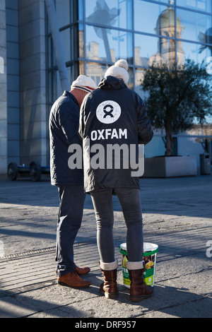 Il centro città di Manchester Oxfam volontari lavoratore, carità persuadere adoperando per iscriversi persone generose per donare tramite addebito diretto. UK, Europa, UE Foto Stock