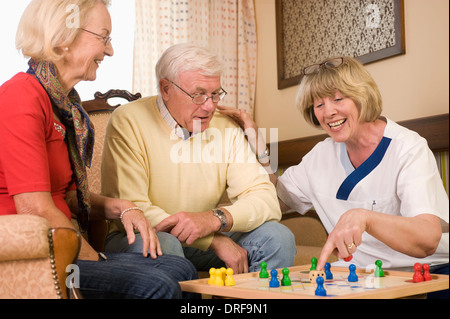 Coppia senior e infermiere gioca ludo insieme, Baviera, Germania Foto Stock