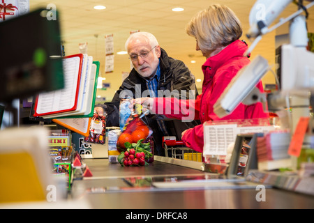 Coppia di anziani acquista in un supermercato, cassiere cassa. Foto Stock