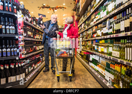 Coppia di anziani acquista in un supermercato. Vino e liquori dipartimento. Foto Stock