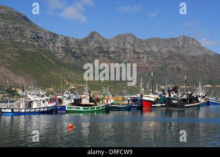 Barche da pesca ormeggiate in Hout Bay Harbor, S Africa, mostrando la table mountain in background Foto Stock