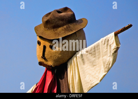 Scarecrow with brown hat and red necktie and white shirt, against a blue sky. Foto Stock