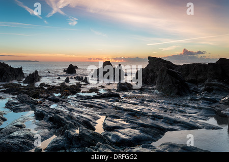 La bassa marea e sunrise sulla spiaggia a Looe in Cornovaglia Foto Stock