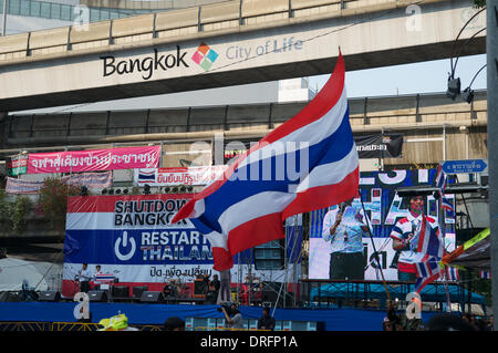 Bangkok, Tailandia. Gennaio 24th, 2014. Un governo anti-protester sventola la bandiera nazionale Tailandese davanti al palco principale dal MBK shopping mall all'intersezione di Pratunam. Dopo quasi 3 mesi di protestare, ci sono ancora decine di migliaia di manifestanti per le strade di Bangkok chiedendo le dimissioni del Primo ministro tailandese Yingluck Shinawatra. 'Shutdown Bangkok' è organizzato dal popolo della riforma democratica Comitato (PDRC). Credito: Kraig Lieb / Alamy Live News Foto Stock