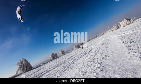 Krasny Les, Repubblica Ceca. 25 gennaio, 2014. Un snow kite rider scivola attraverso il bianco paesaggio invernale durante una giornata di sole in montagne Erz vicino a Krasny Les, Repubblica ceca, 25 gennaio 2014. Foto: Arno Burgi/dpa/Alamy Live News Foto Stock