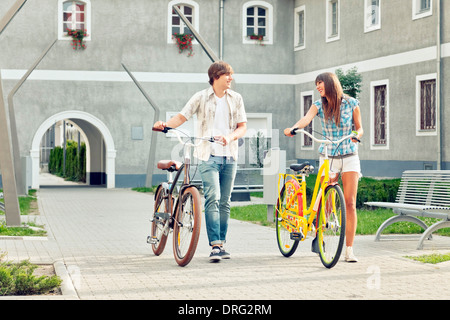 Coppia giovane spingendo le biciclette, osijek, Croazia Foto Stock