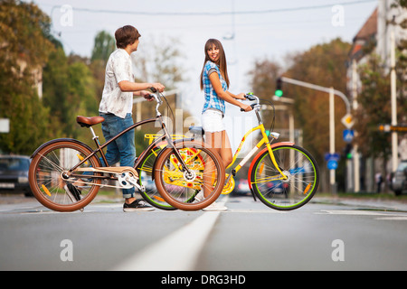 Coppia giovane spingendo le biciclette insieme, osijek, Croazia Foto Stock