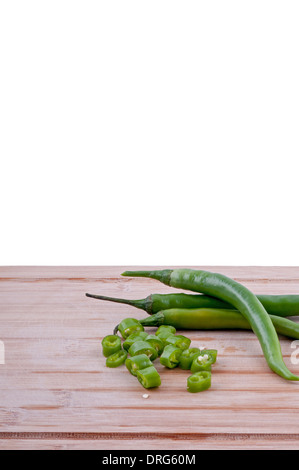Un trito di peperoncini verdi con la pila di peperoncini verdi su invecchiato boarrd chopping e sfondo bianco verticale. Foto Stock