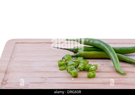 Un trito di peperoncini verdi con la pila di peperoncini verdi su invecchiato boarrd chopping e sfondo bianco. orizzontale Foto Stock
