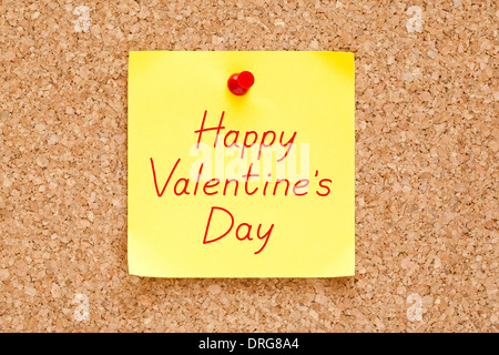 Buon San Valentino scritto su un bigliettino giallo imperniata su un tappo di sughero bulletin board. Foto Stock