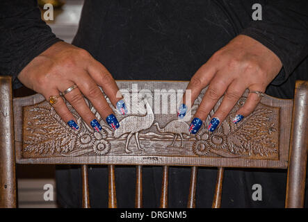Le mani con le unghie verniciate con bandiere australiano poste su antichi intagliati Australiana sedia. Foto Stock