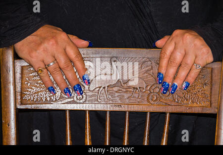 Le mani con le unghie verniciate con bandiere australiano poste su antichi intagliati Australiana sedia. Foto Stock