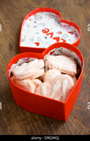 A forma di cuore i cookie di noce di cocco in un cuore rosso scatola sagomata. Foto Stock