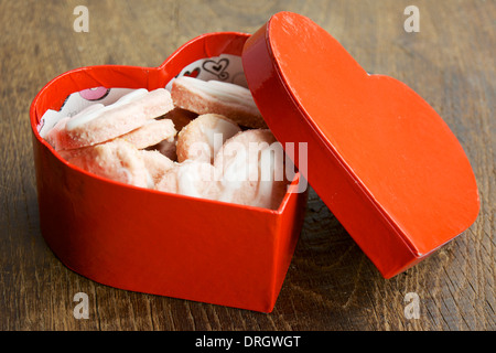 A forma di cuore i cookie di noce di cocco in un cuore rosso scatola sagomata. Foto Stock