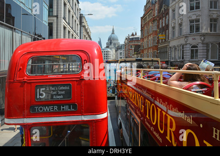 I passeggeri su open top gita turistica in autobus in ingorghi di traffico a fianco di un numero 15 routemaster double decker red London bus Foto Stock