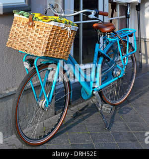 Maastricht City Ladies Locked Blue Gazelle bike dotata di grande cesto di vimini montato anteriormente parcheggiato in stand in via Limburgo Paesi Bassi Europa e UE Foto Stock