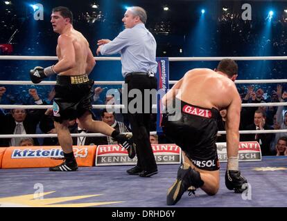 Stuttgart, Germania. 26 gen 2014. Tedesco campione WBO Marco Huck (L) in azione contro la prima Arslan che si inginocchia sul pavimento (R) durante il loro World Boxing Organization (WBO) Cruiserweight Championship corrispondono a Schleyer Hall a Stoccarda, Germania, 26 gennaio 2014. Huck ha vinto contro il Challenger prima Arslan dal tecnico k.o. nel sesto round. Foto: SEBASTIAN KAHNERT/dpa/Alamy Live News Foto Stock