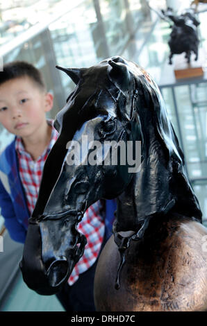 (140127) -- Qingdao , Gen 27, 2014 (Xinhua) -- Un ragazzo vedute di una scultura di cavallo in una mostra a Qingdao, Cina orientale della provincia di Shandong, Gennaio 26, 2014. Una mostra di sculture di cavalli si è svolta a Qingdao per celebrare il prossimo anno del cavallo durante il Festival di Primavera di periodo. (Xinhua/Li Ziheng) (AF) Foto Stock