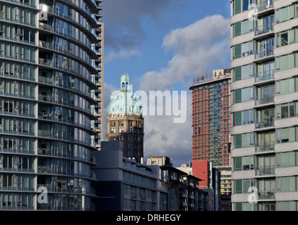 Storico edificio di sole tra più alto edificio di appartamenti nel centro cittadino di Vancouver, Canada. Alta densità di vita urbana della città. Foto Stock