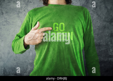 Un uomo indica di andare verde titolo stampato sulla sua maglietta, uno stile di vita sano concetto. Foto Stock