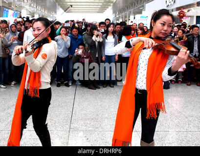 Shanghai, Cina. 27 gennaio, 2014. I volontari svolgono il violino per sorpreso passeggeri presso la lobby e di Hongqiao Stazione Ferroviaria di Shanghai, Cina orientale, Gennaio 27, 2014. Un gruppo di Mobs istantanei raccolte di Hongqiao Stazione ferroviaria il lunedì ed eseguito canti e danze per i passeggeri che sono sulla loro strada di casa durante il Festival di Primavera di viaggio rush. Credito: Chen Fei/Xinhua/Alamy Live News Foto Stock