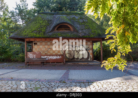 Il vecchio tetto di paglia in disuso e piastrella chiosco coperto di graffiti a Spreepark abbandonato parco divertimenti Plånterwald, Berlino Foto Stock