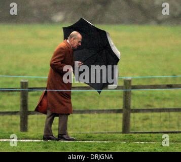 Sandringham, Norfolk, Regno Unito. 26 gen 2014. Sua Maestà la Regina Elisabetta II che frequentano la Chiesa al Sandringham. Il Principe Filippo , Duca di Edimburgo, battaglie con un ombrello sotto la pioggia andando a Santa Maria Maddalena la Chiesa per domenica mattina il servizio in Sandringham. Pic: Paolo Marriott Fotografia/Alamy Live News Foto Stock