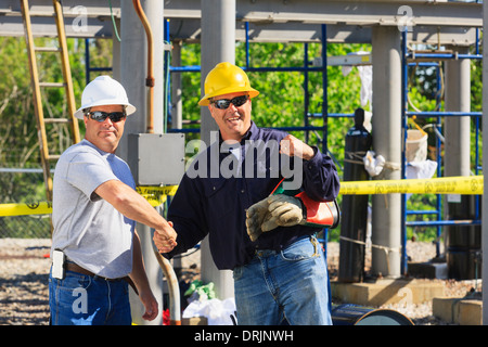 Gli ingegneri di potenza stringe la mano ad alta tensione di alimentazione della stazione di distribuzione, Braintree, Massachusetts, STATI UNITI D'AMERICA Foto Stock