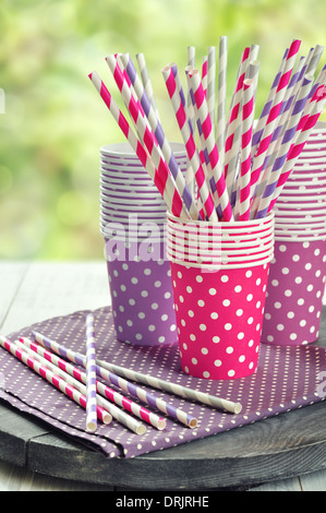 Carta colorata tazze e striato cannucce per la festa di compleanno. Foto Stock