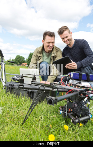 I tecnici a discutere su tavoletta digitale da UAV Foto Stock